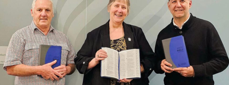 From left to right, Murray Hunter, Jean Carter, and Jacques Calais holding copies of the new Abide Bible. [Photo: Adventist Record]