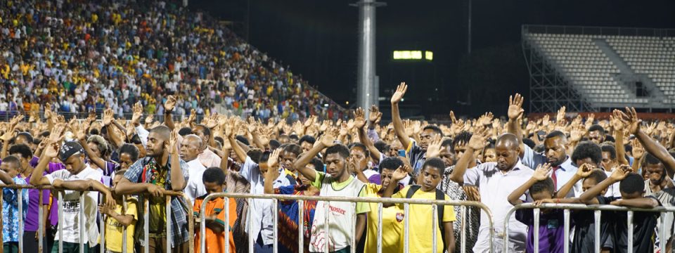 People in the crowd at the Sir John Guise Stadium raise their hands to an appeal from General Conference president Ted N. C. Wilson in Port Moresby, Papua New Guinea, on April 25. [Photo: Adventist Record]