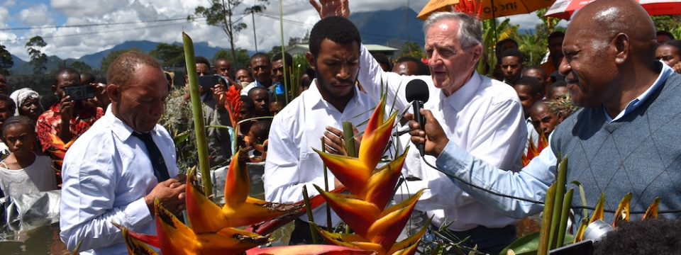 Retired ADRA leaders Wally Amundson (second from right) prays for one of the candidates before baptizing him at one of the evangelistic venues in Mount Hagen, Western Highlands, Papua New Guinea, on May 4. [Photo: Marcos Paseggi, Adventist Review]