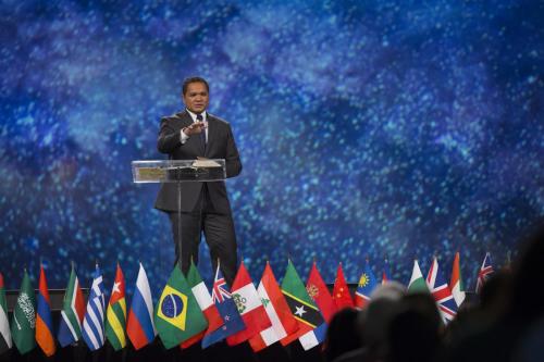GYC president Moise Ratsara shares the keynote message on opening night of the annual national convention at the George R. Brown Convention Center in Houston, Texas, United States. Flags on stage represented the nations from which attendees came. [Photo: Seth Shaffer]