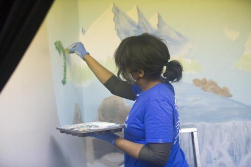 Marliano Smith paints a mural in a baptistry during outreach at GYC 2020.